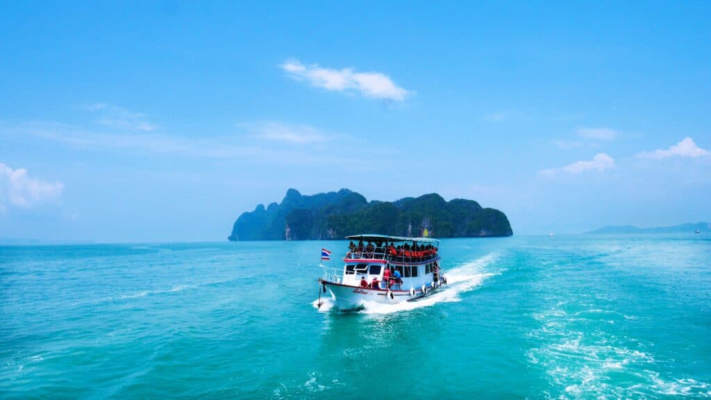 Phuket to Phi Phi and Krabi by ferry, passing an island in calm blue seas