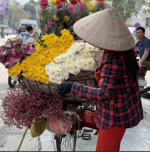 Buying flowers from seller with bicycle in Hanoi with kids