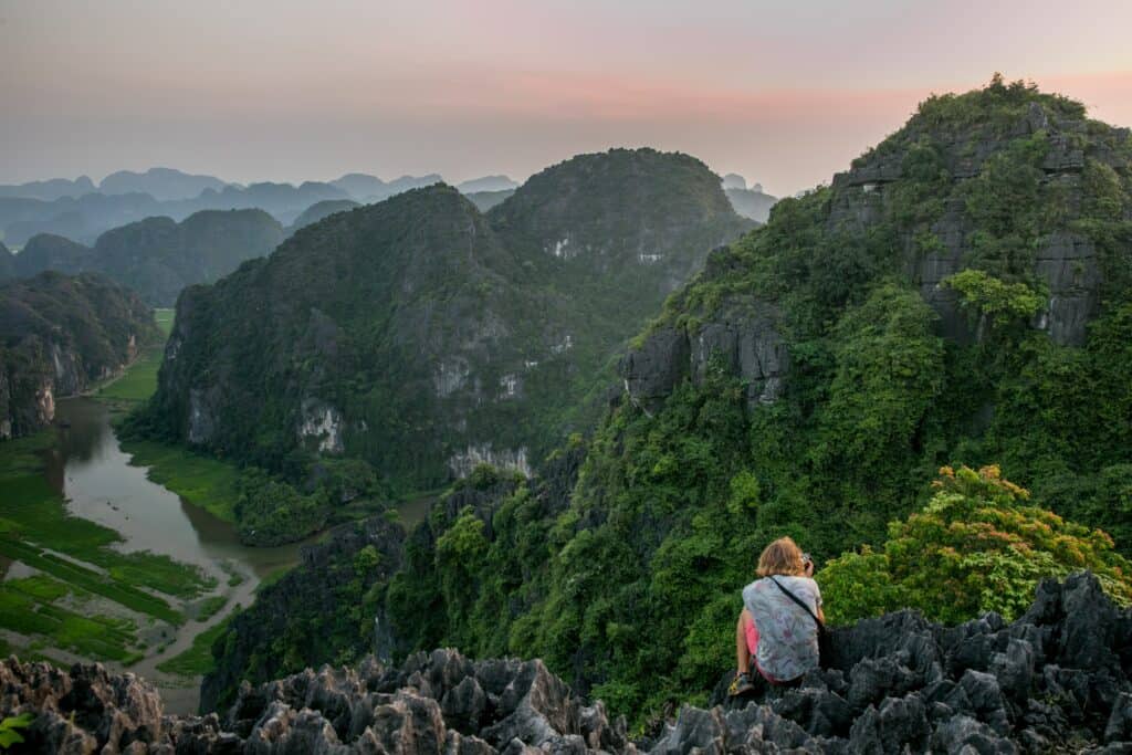view from the top of mountains in Ninh Binh with person in foreground, part of a 10 day Vietnam itinerary
