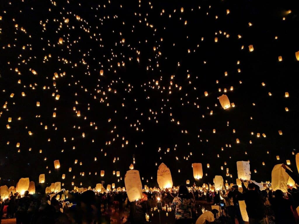 Paper lanterns being set off into the night sky for the Yee Peng Lantern Festival