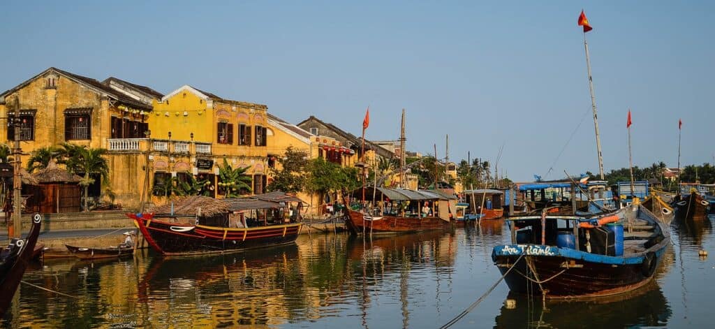 Where to Stay in Hoi An: Boat on the river in front of yellow building