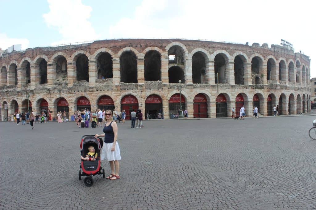 Woman in front of the Roman Arena in Verona with a baby in a stroller