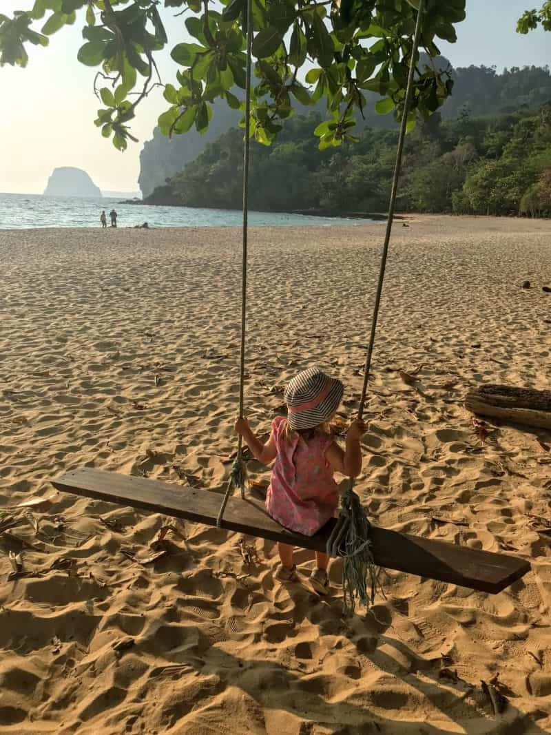 Young girls on a swing on Charlie Beach Koh Mook