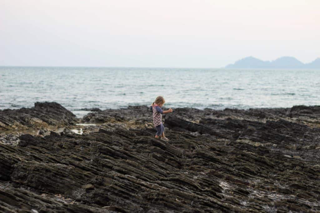 Young girl climbing rocks in Koh Mook