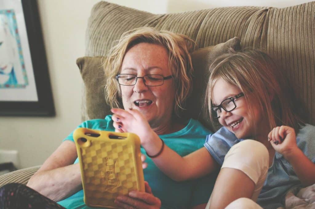 Woman and girl using tablet playing on one of he best apps for toddlers