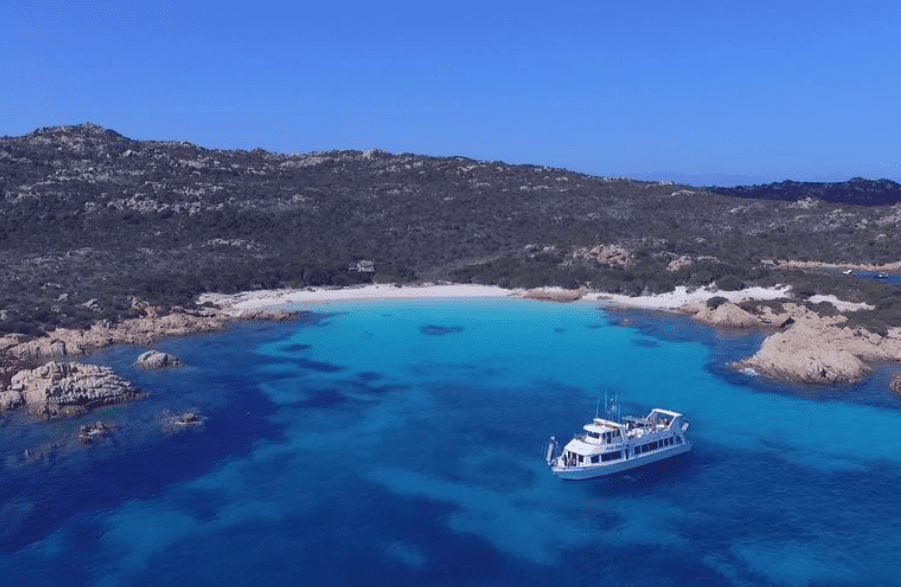 La Maddalena Boat Trip in blue bay with island behind