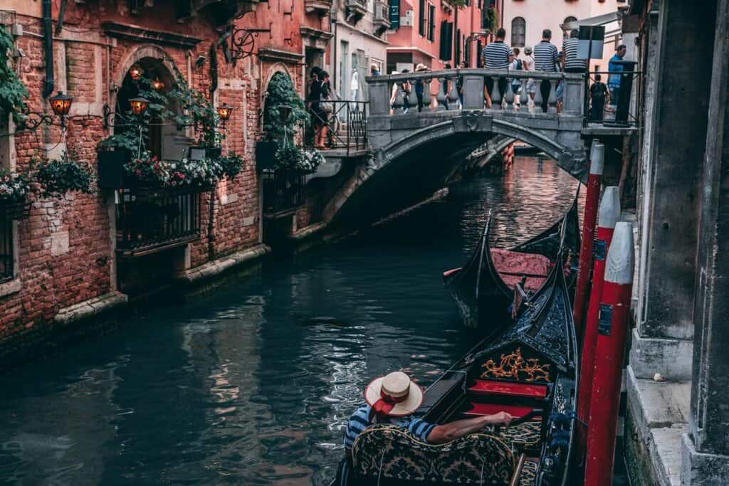 Gondola floats towards bridge in Venice