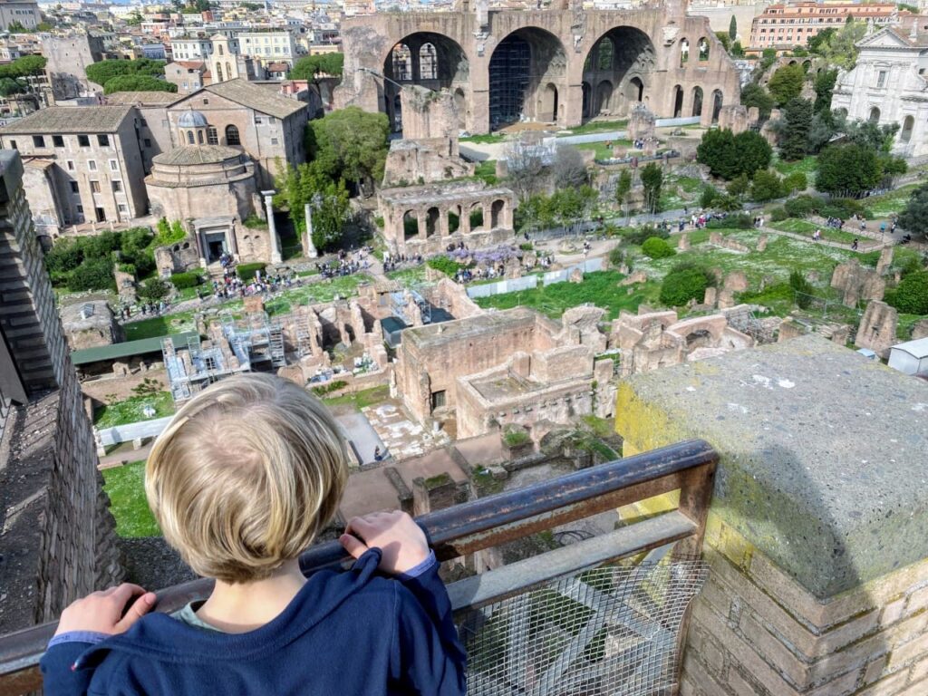 Chilld looks down at the Roman forum, one fo the best things to do in Rome with kids